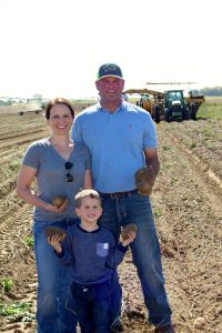 Josh and Jenn Bunger and their son, Elliot, show off some Ranger Russets harvested on their Pasco, Wash. farm.